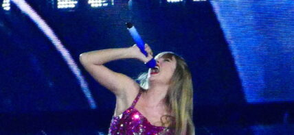 Taylor Swift holds a light saber style prop as bicycles and cars go by her in amazing visual show on stage during first weekend of her tour in Arizona