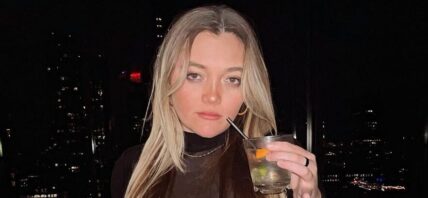 Julz Dunne posing for the camera while holding her drink.