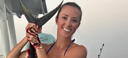 Vicky Stark in a printed bikini poses for the camera while showing off the big fish she caught.