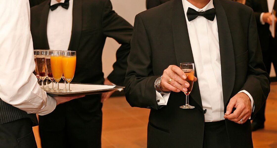 Man in a tux holding a glass of champagne