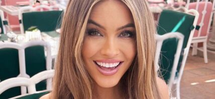 Chrishell Stause smiles at an outdoor table