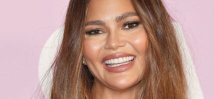 Chrissy Teigen smiles at an event
