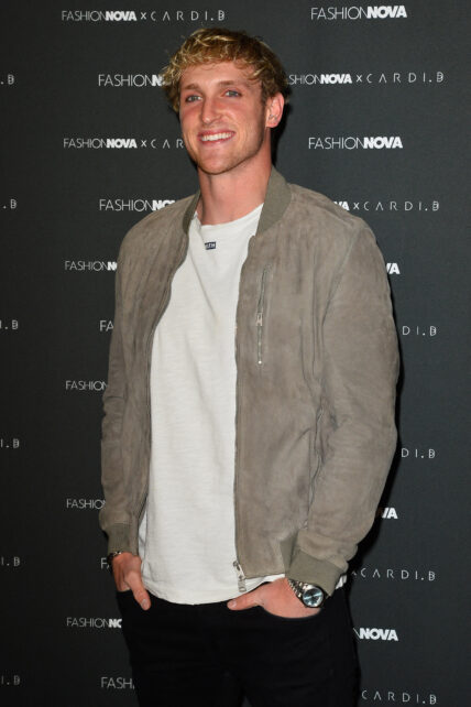 Logan Paul smiling in a green jack on the red carpet.