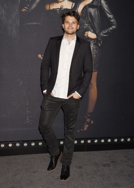 Tom Schwartz posing in a black jacket and white shirt