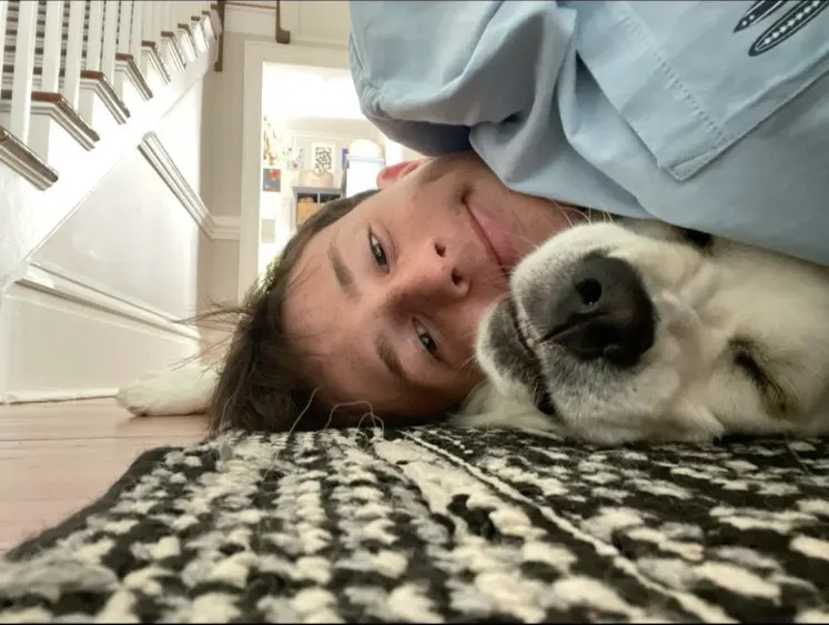 Miller Gardner laying on the floor with dog