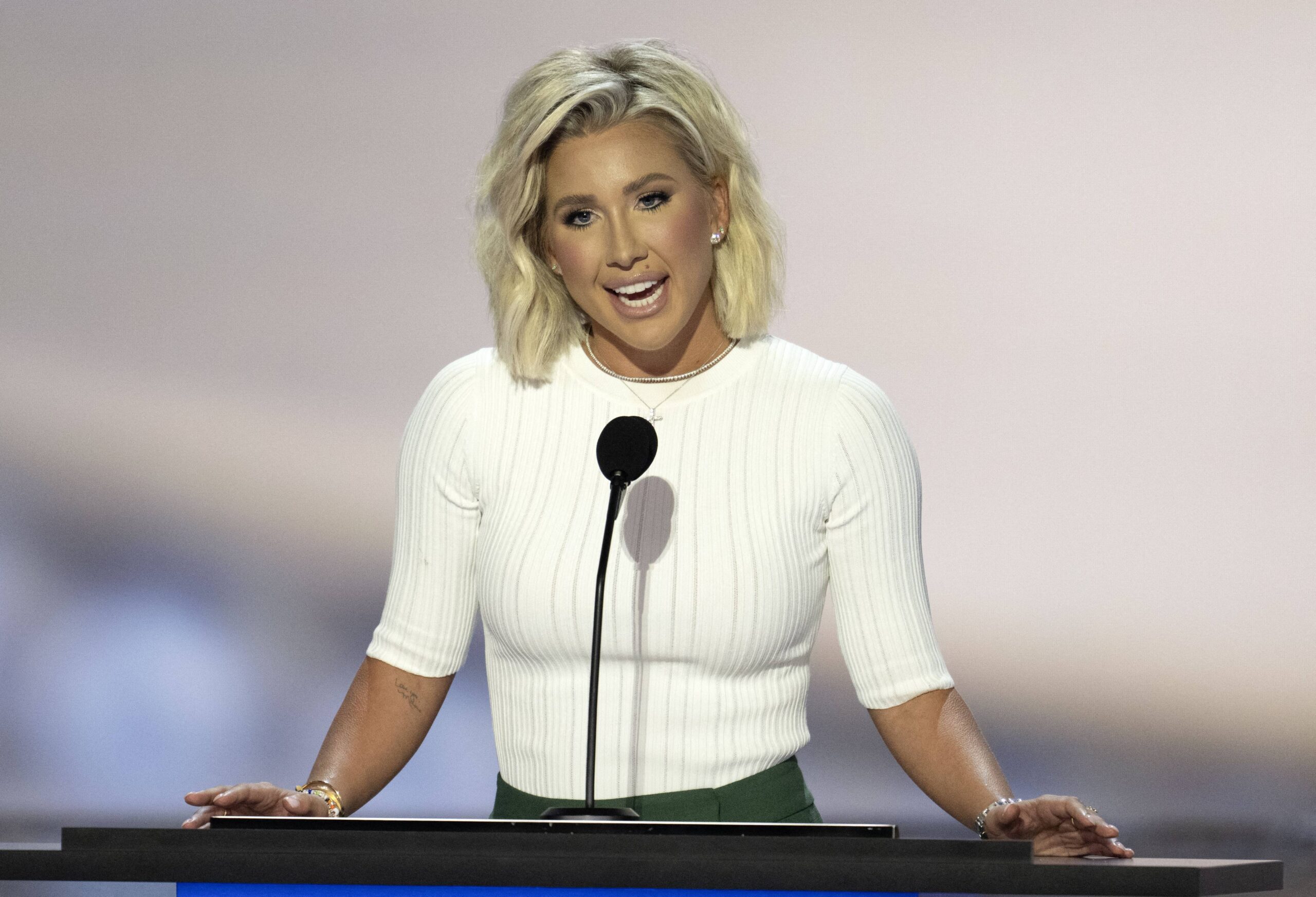 Savannah Chrisley speaking in front of a crowd of people at the RNC.