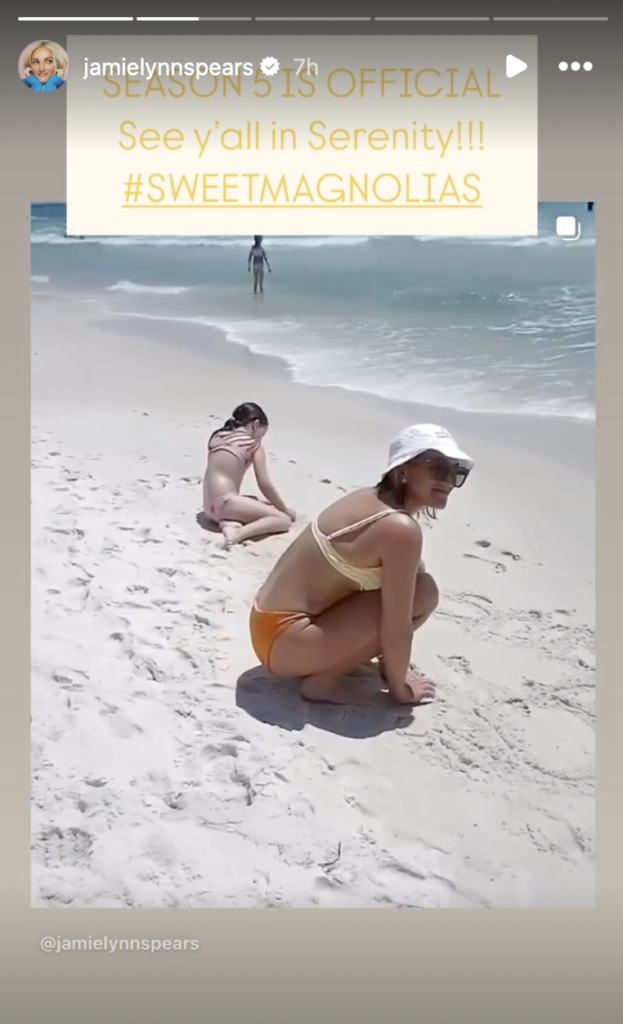 Jamie Lynn Spears writes on the sand.