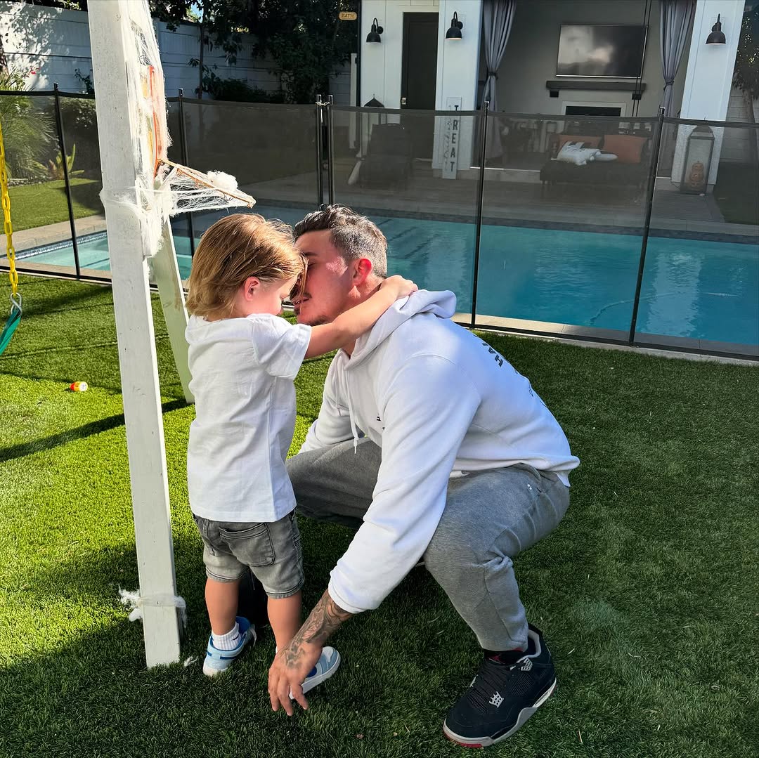 Jax Taylor playing with his son Cruz in the yard.