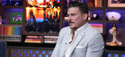 Jax Taylor in a grey suit sitting on the set of Andy Cohen's 'Watch What Happens Live.'