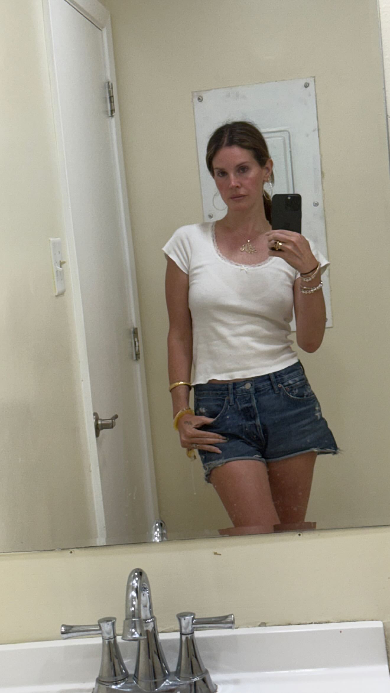 Lana Del Rey poses in front of a mirror