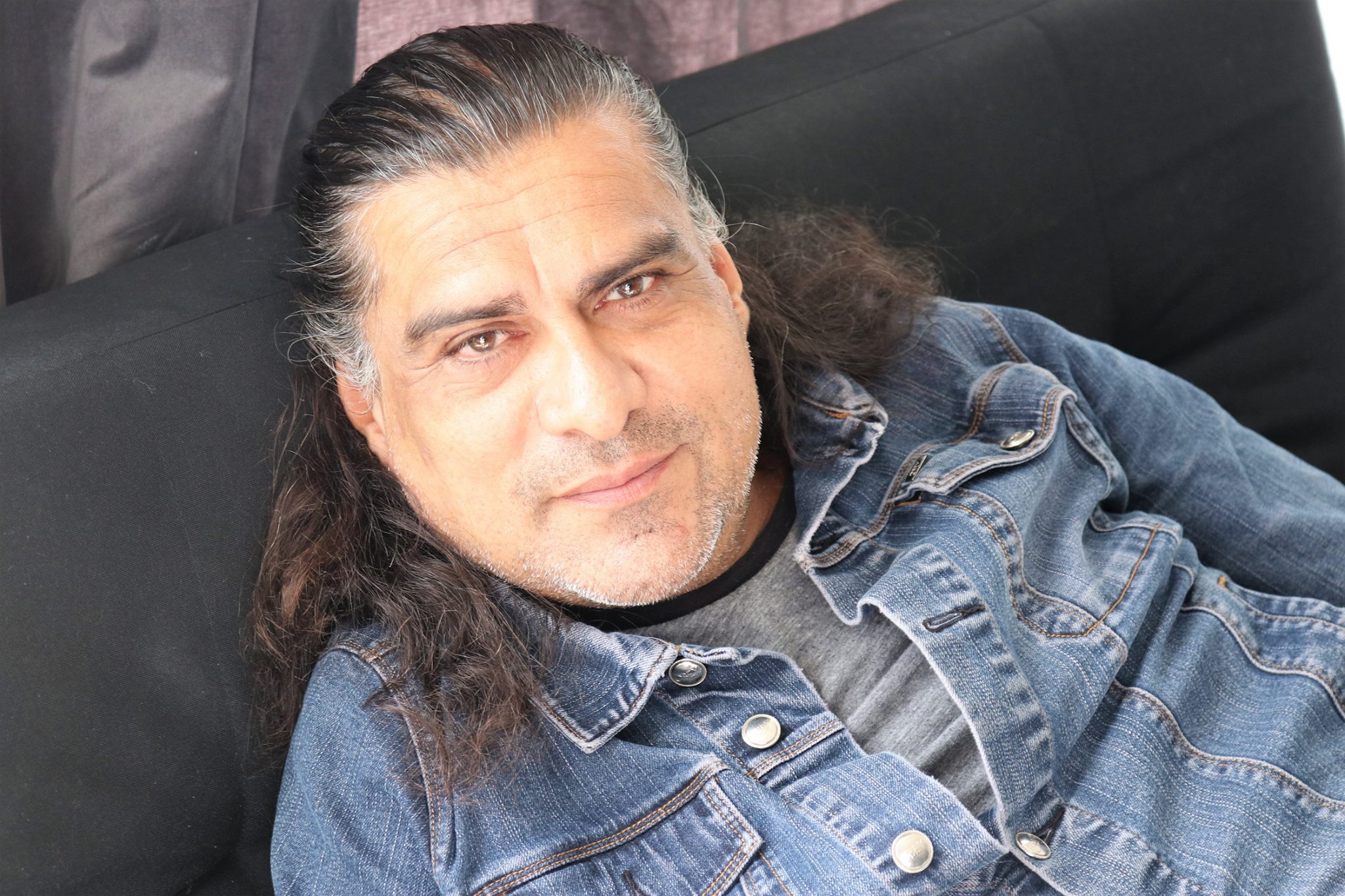 A photo of Jonathan Joss resting on a couch