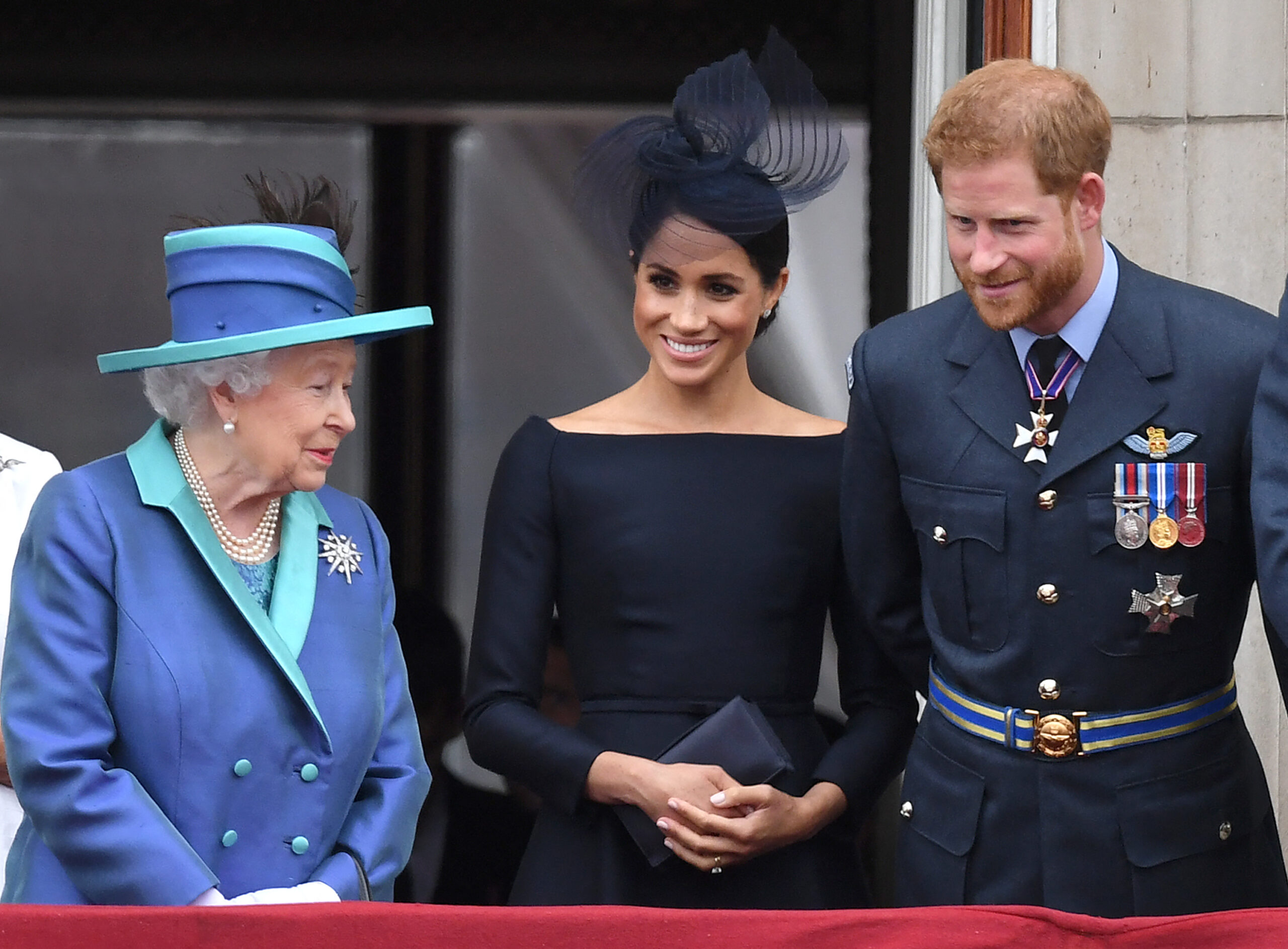 Queen Elizabeth with Meghan Markle and Prince Harry the Royal Family watch the RAF100 flypast