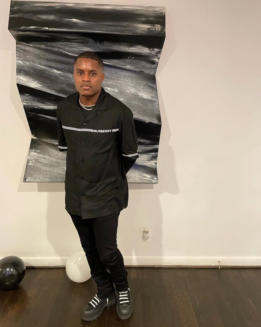 Christian Coleman posing in front of a painting.