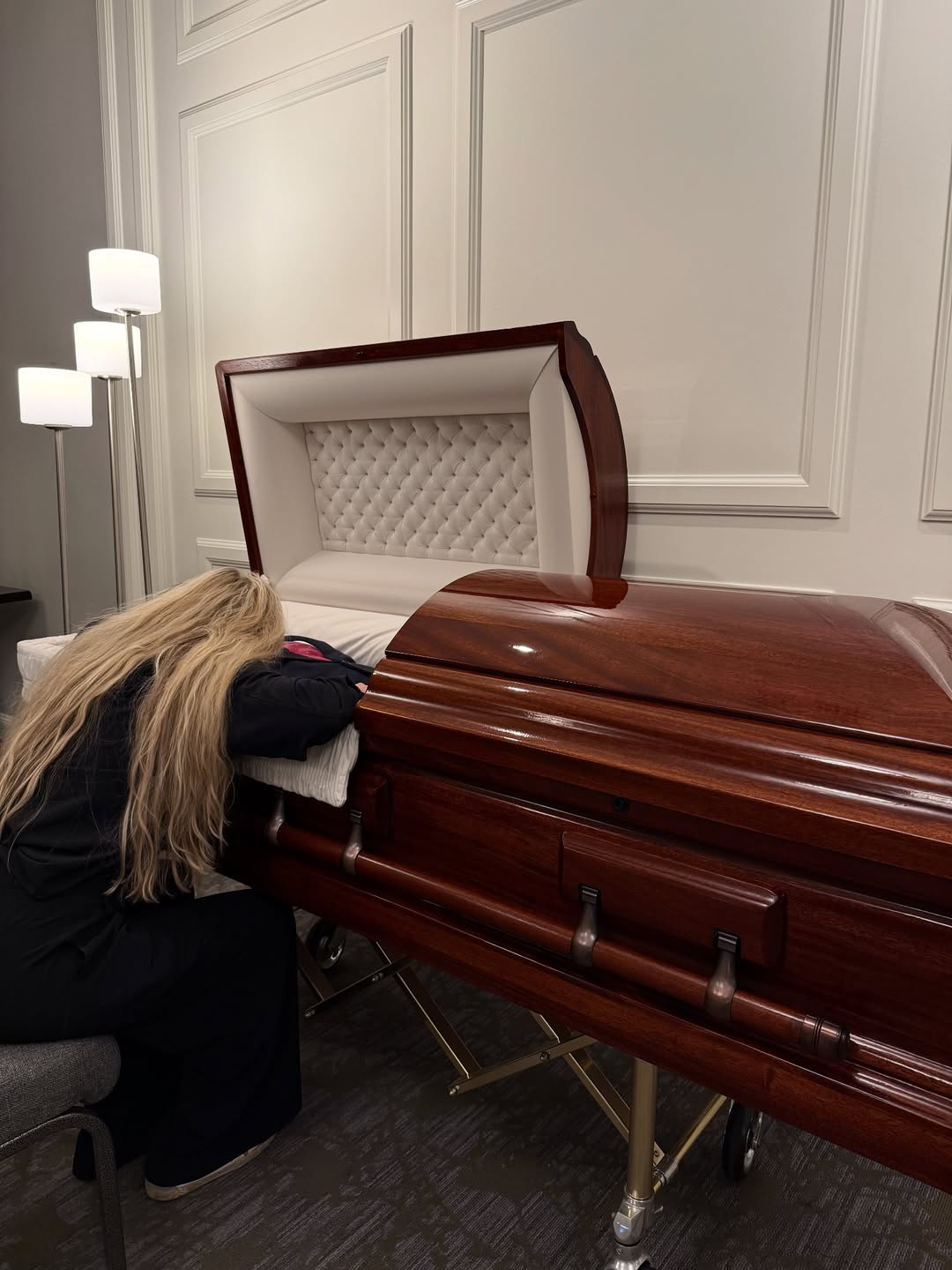Erika Kirk leaning over Charlie Kirk's casket