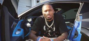 Isaiah Rodgers posing for a picture inside of a car.