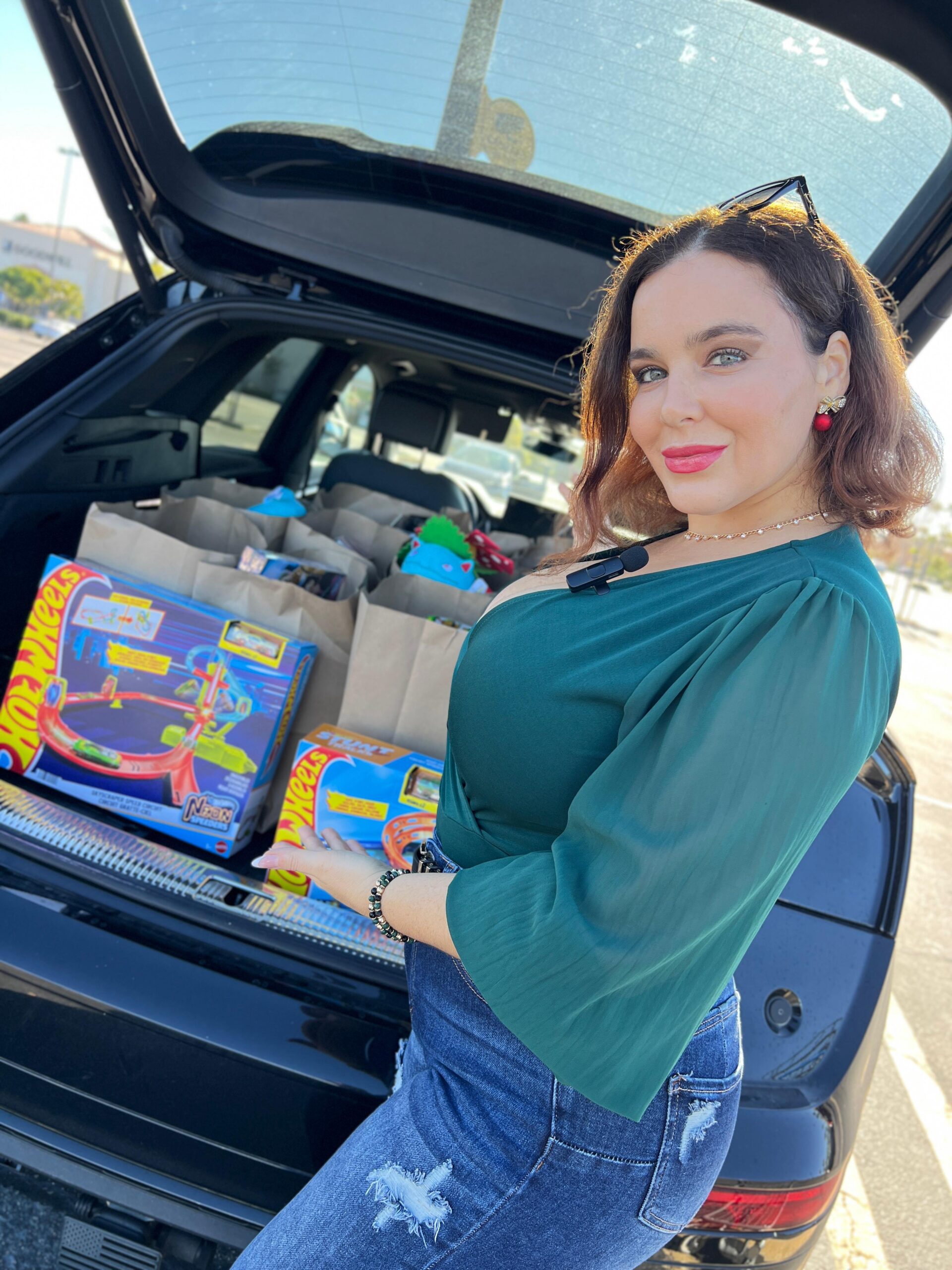 Natasha showing off toys in the trunk of a car