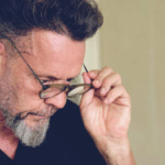 Man with glasses looking down