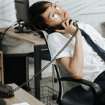 Man slumped over in chair on phone