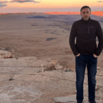 Man standing in desert at sunset