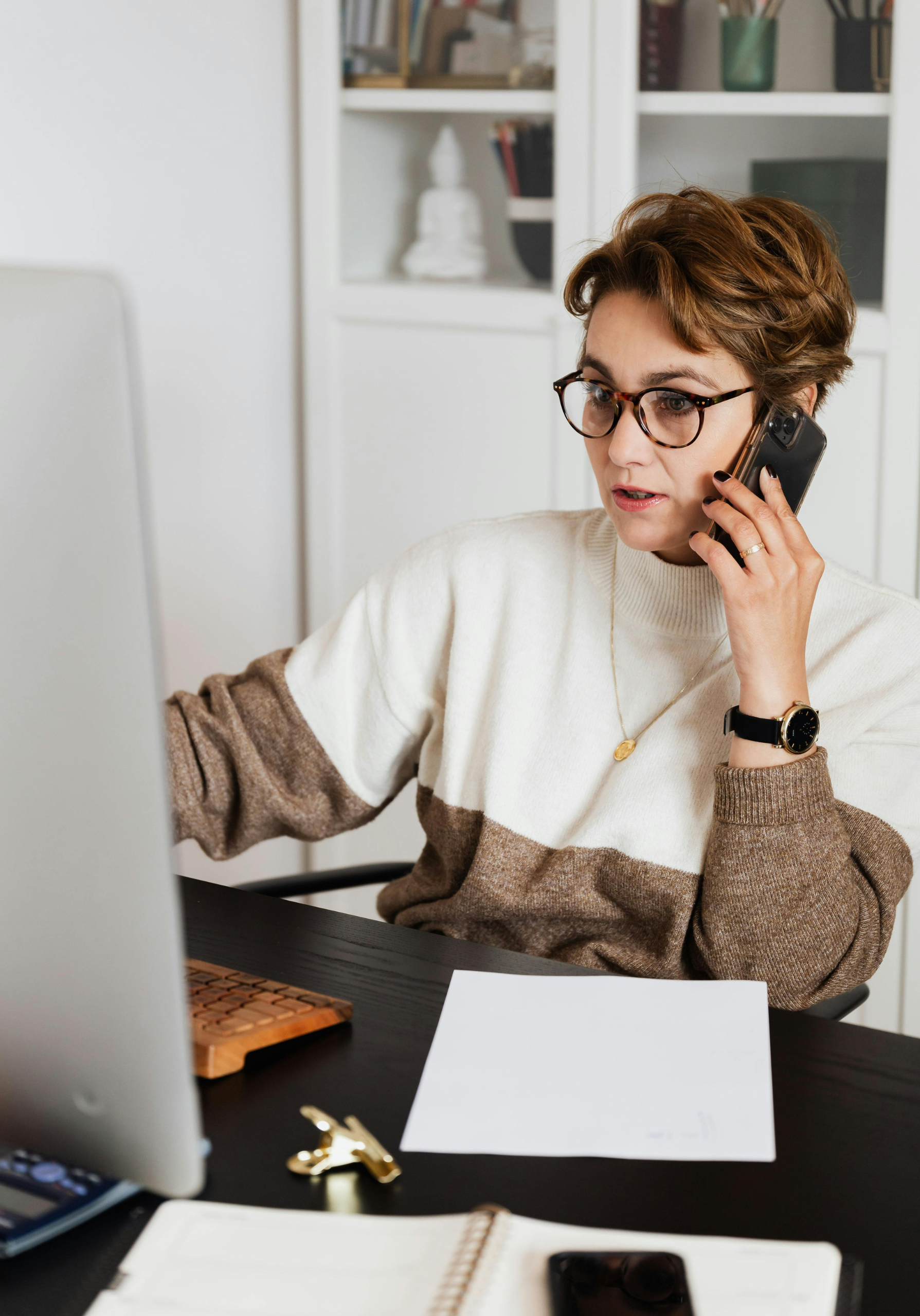 Woman on phone in front of computer