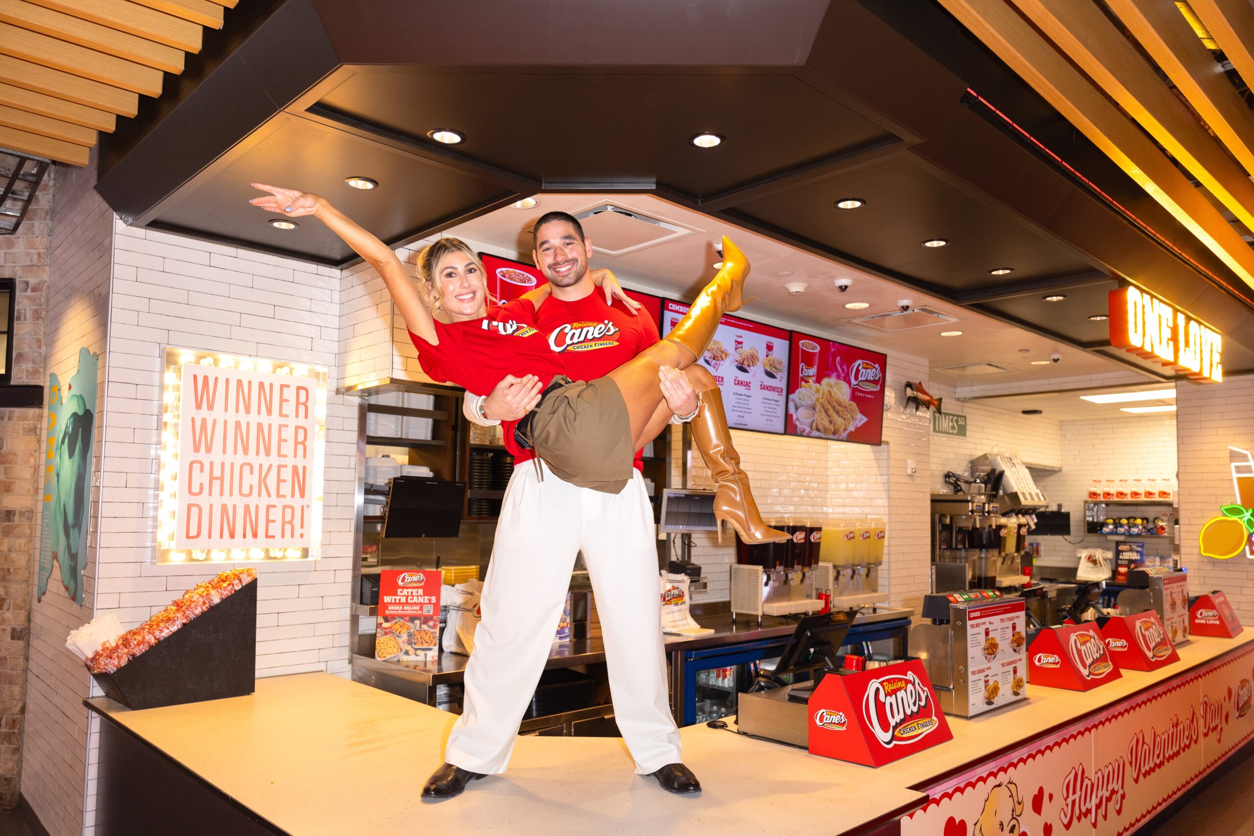Alan Bersten holding Emma Slater on Raising Cane's counter