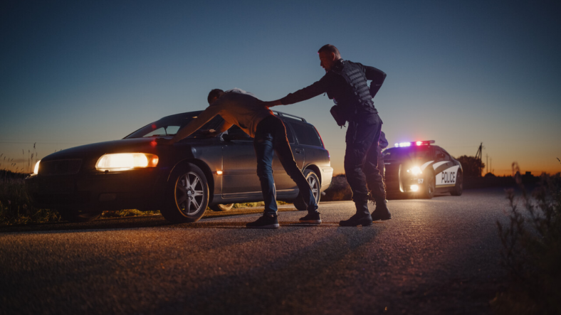 Officer pulling someone over in a traffic stop. 