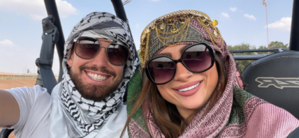 Man and woman with sunglasses smiling for the camera.