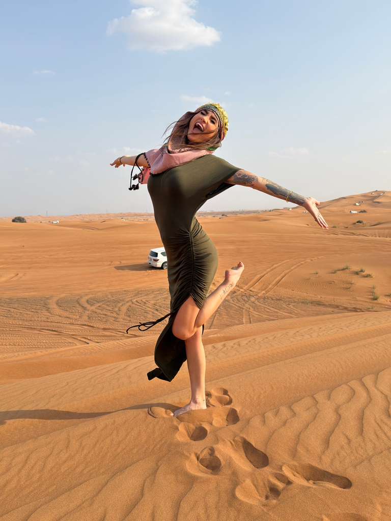 Woman in green dress posing in the desert.