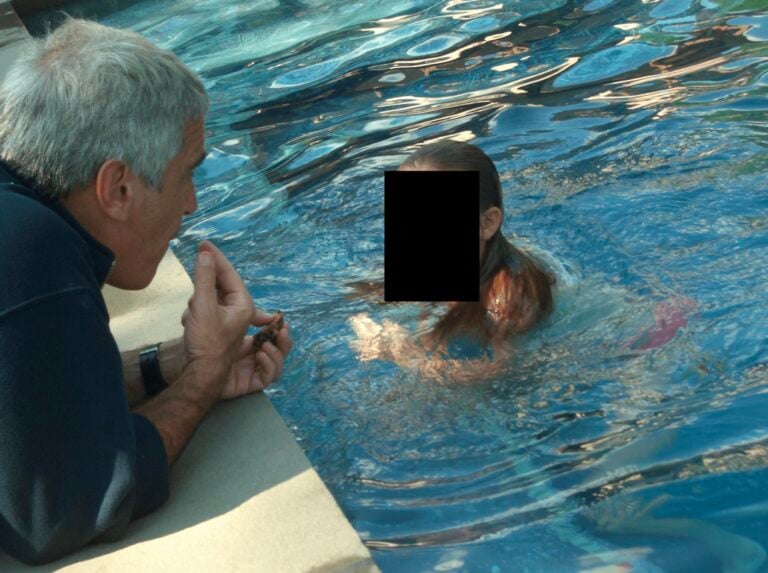 Jeffrey Epstein osing with what appears to be a child in these undated photo released by the U.S. Department of Justice