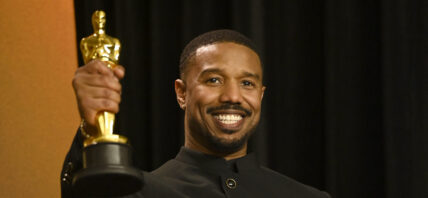 Michael B. Jordan posing with his Oscar on the red carpet.