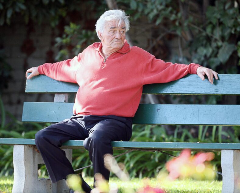 Peter Falk resting during walking his dog with his wife
