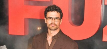 Theo James in a brown suit