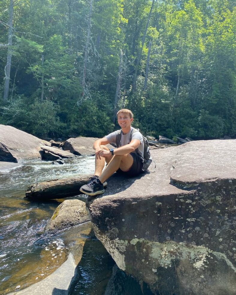 Dylan Carter sitting on a rock