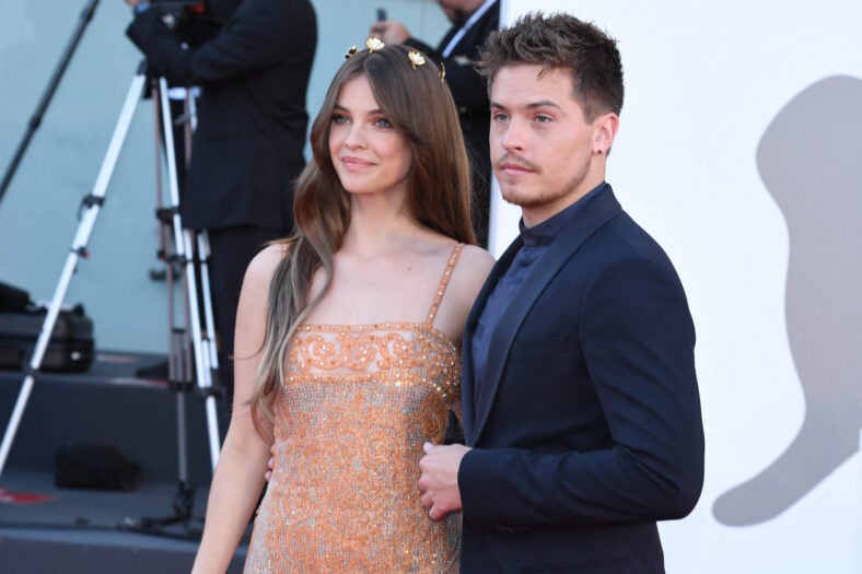 Dylan Sprouse posing on the red carpet with his wife. 