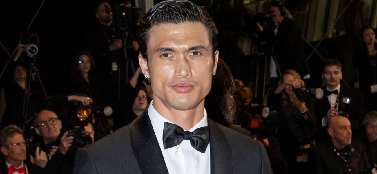 Charles Melton flexiona seus bíceps tonificados em shorts vermelhos