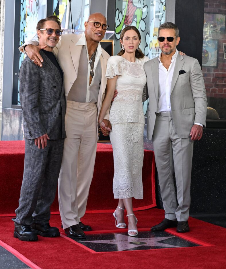 Dwayne Jonson posing with Emily Blunt, Robert Downey Jr., and Matt Damon