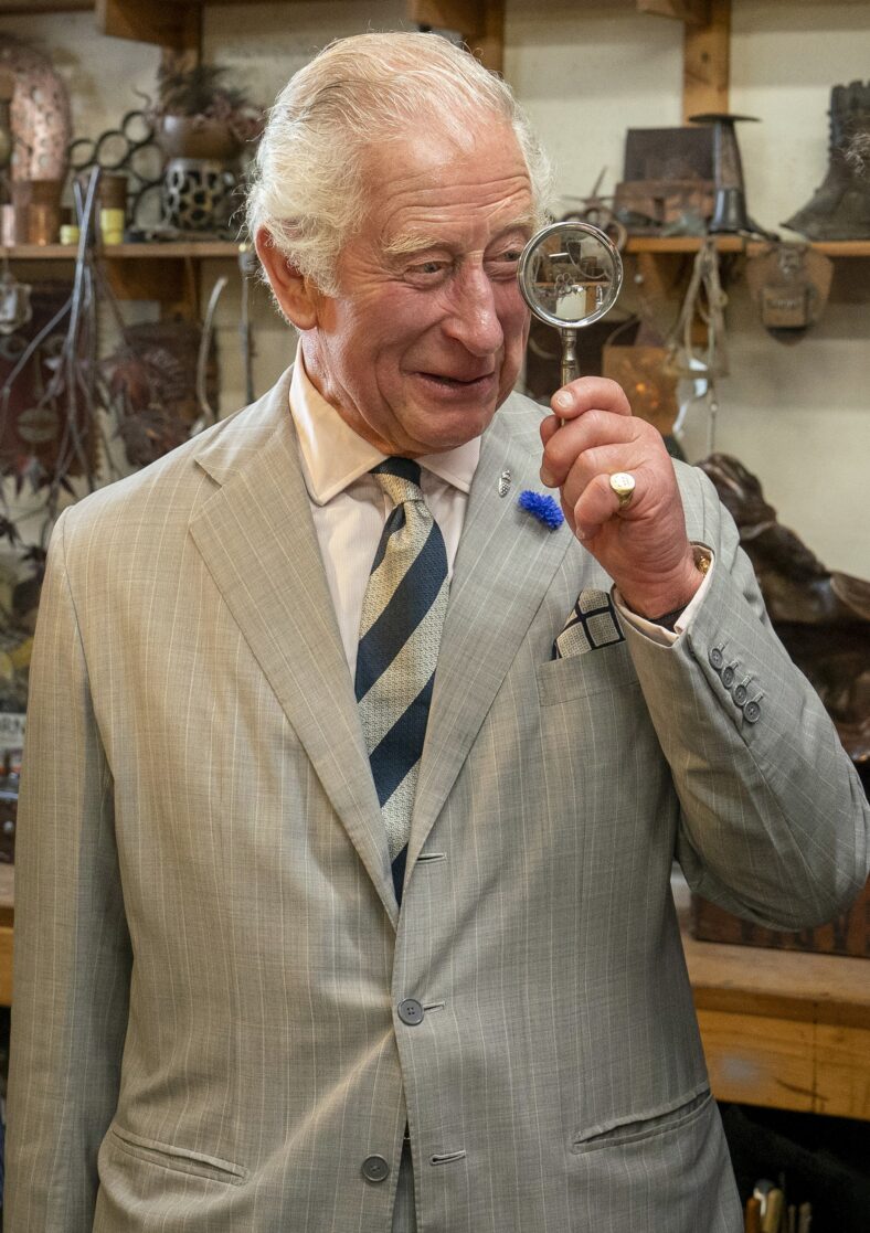 Prince Charles holds up a magnifying glass