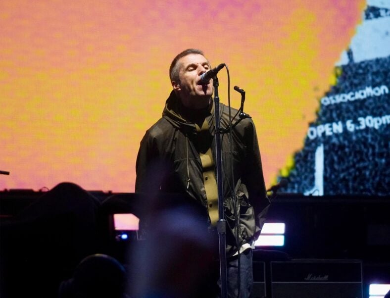 Noel and Liam Gallagher share a hug at the end of Oasis' triumphant reunion show in Cardiff